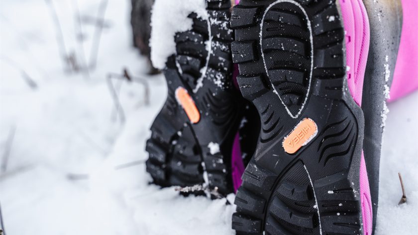 A woman is walking in the snow wearing HISEA snow boots.