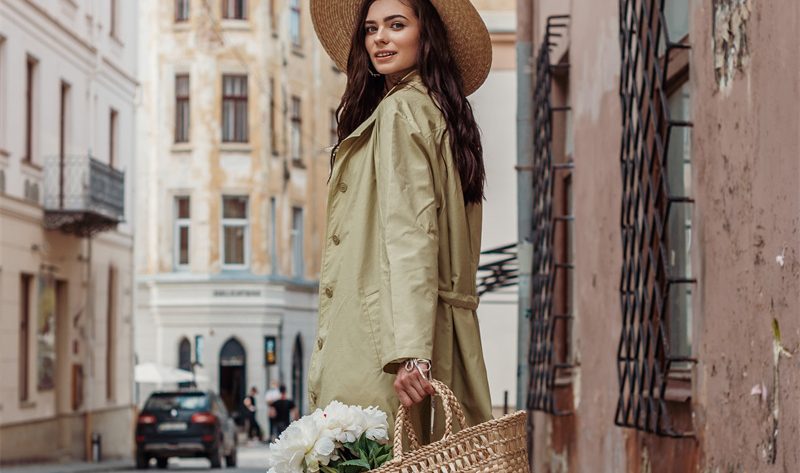 An elegant woman is carrying a handbag with some beautiful flowers inside and is wearing HISEA cowboy boots.